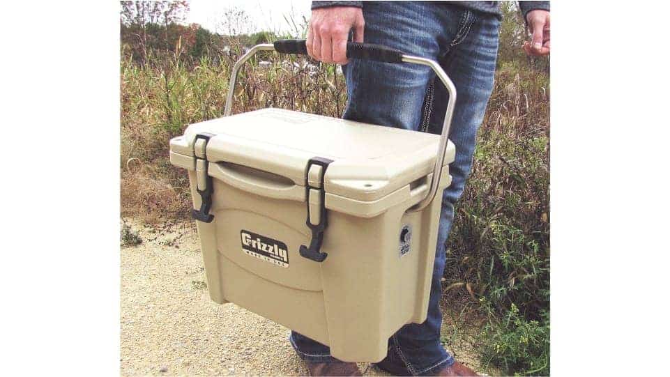 man holding grizzly 15 cooler with stainless steel handle