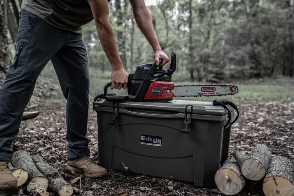 Chainsaw Sitting Ontop Of Durable Grizzly Cooler