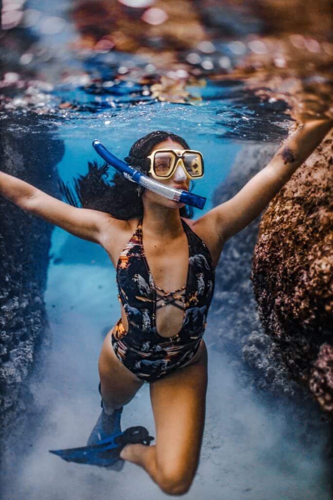 woman snorkeling around coral