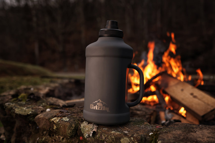 64 oz water bottle, in front of outdoor fire at campsite
