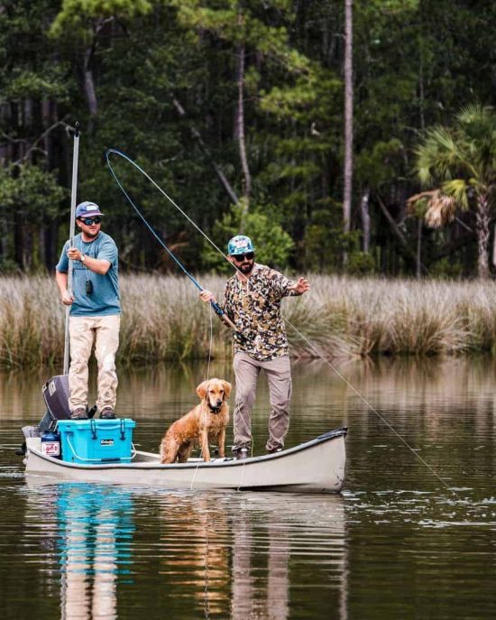 Two Men And Dog On Canoe Fly Fishing With Grizzly Hard Sided Cooler
